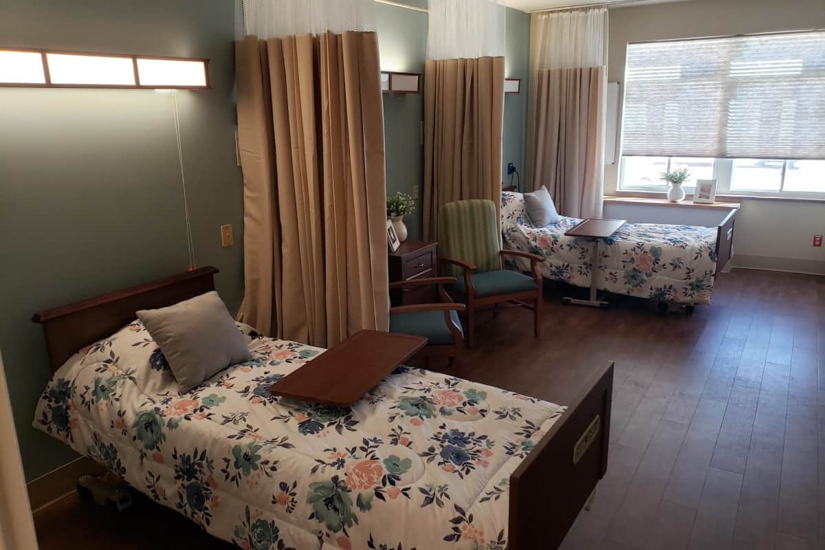 Private resident room with two beds and seating