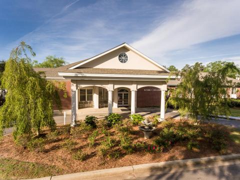 Exterior view of a nursing home facility with gardens