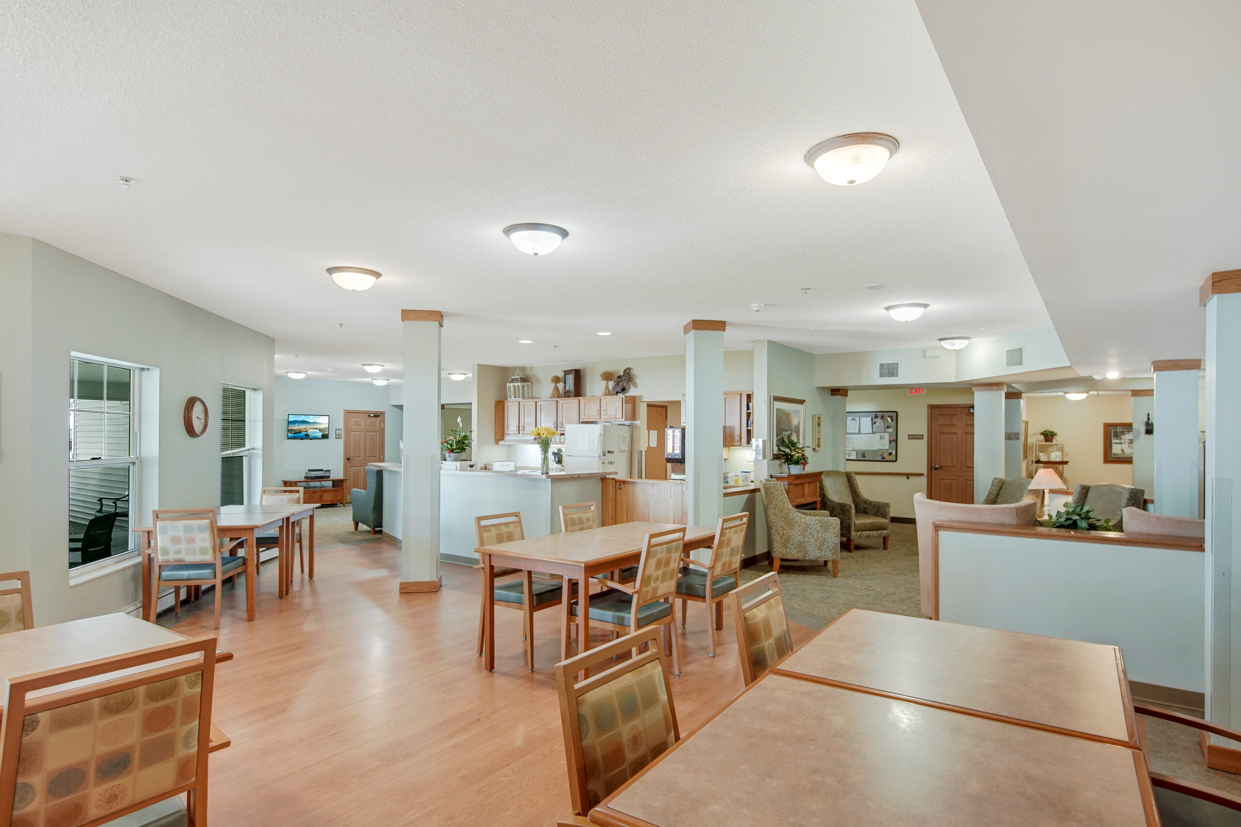 Common area with tables and seating in a senior living facility