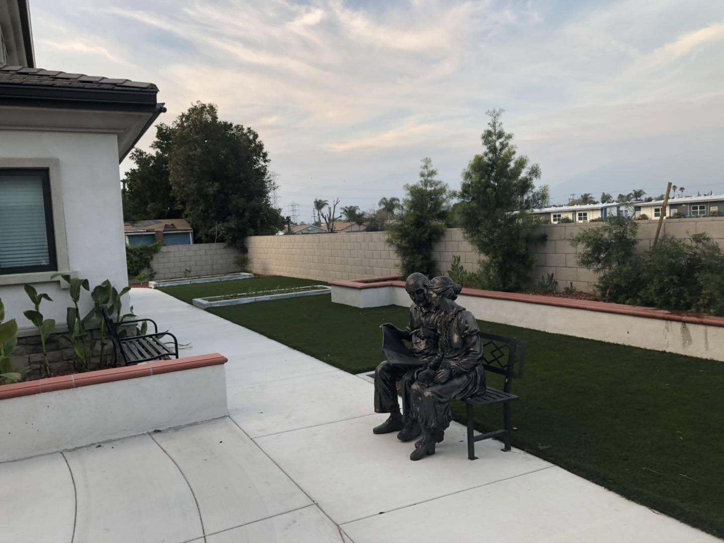 Outdoor common area with a sculpture of two seated elders