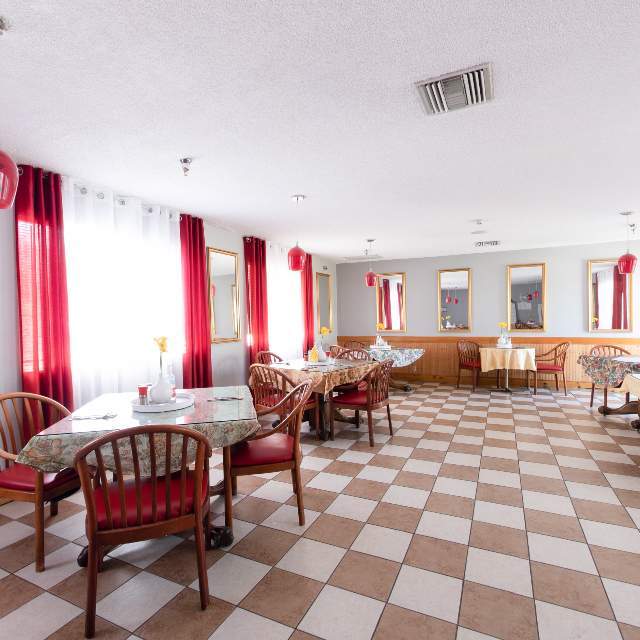 Bright dining area with checkered flooring and red accents