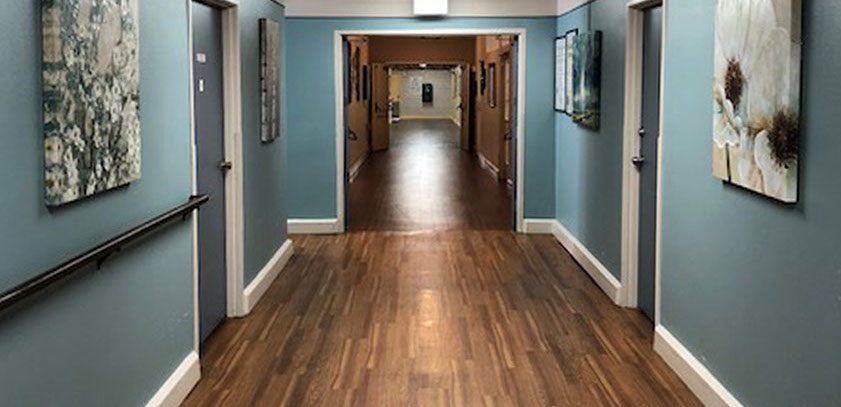 A well-lit hallway with artwork and wooden flooring
