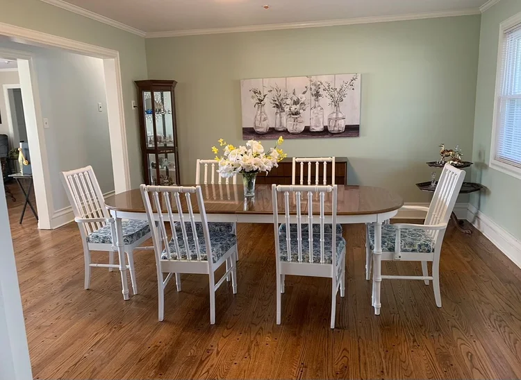 Bright dining room with floral centerpiece and white chairs