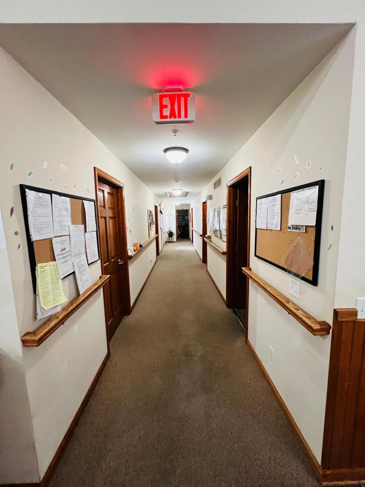 Interior hallway with exit sign and bulletin boards