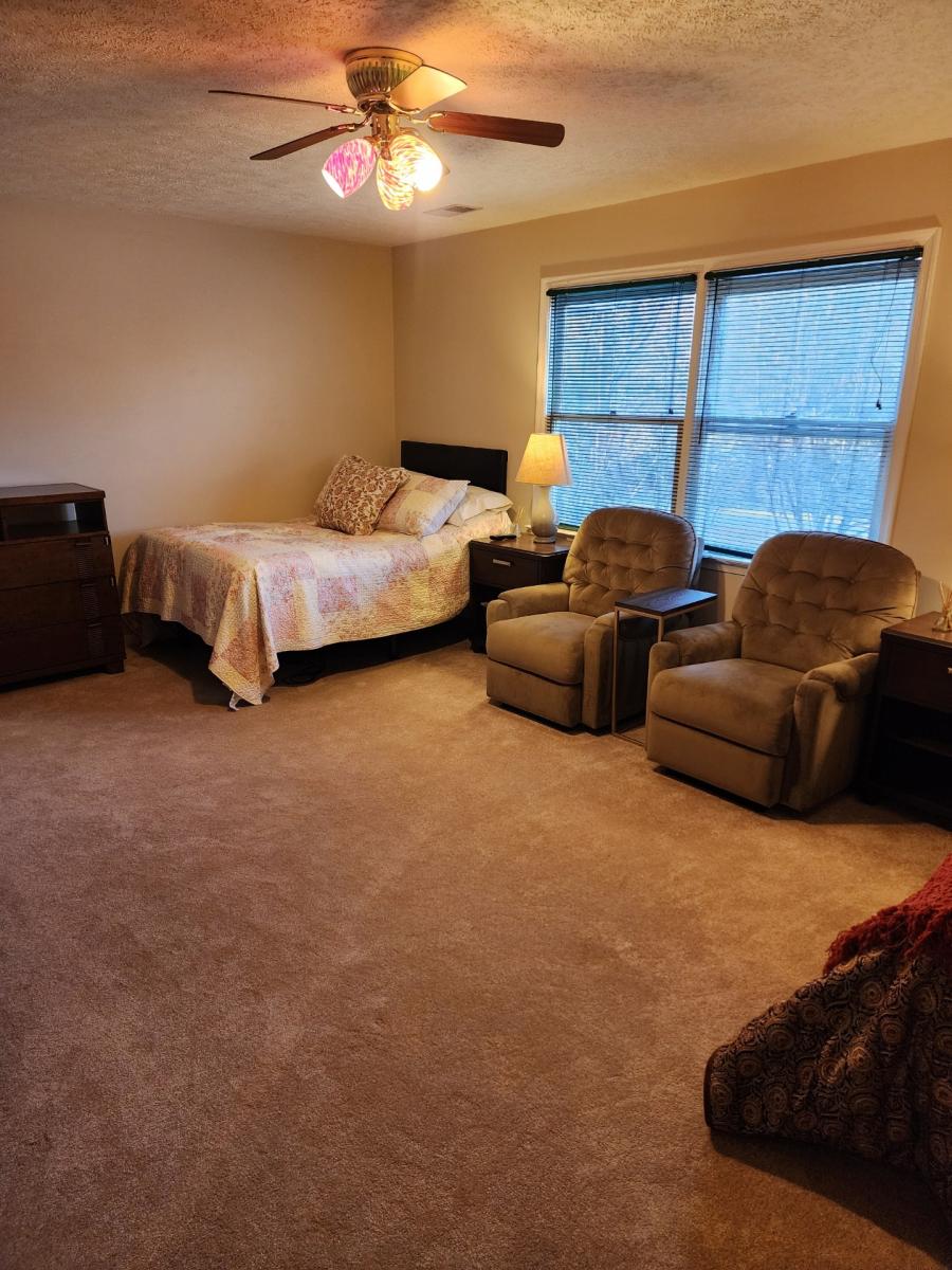 Cozy furnished bedroom with two chairs and a bed