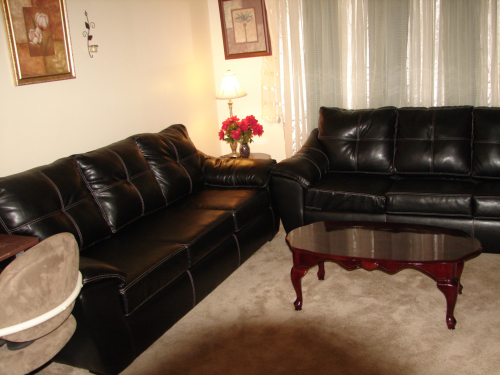 Cozy living room with black sofas and coffee table.