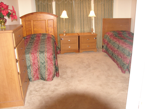 Cozy shared bedroom with two beds and furniture.