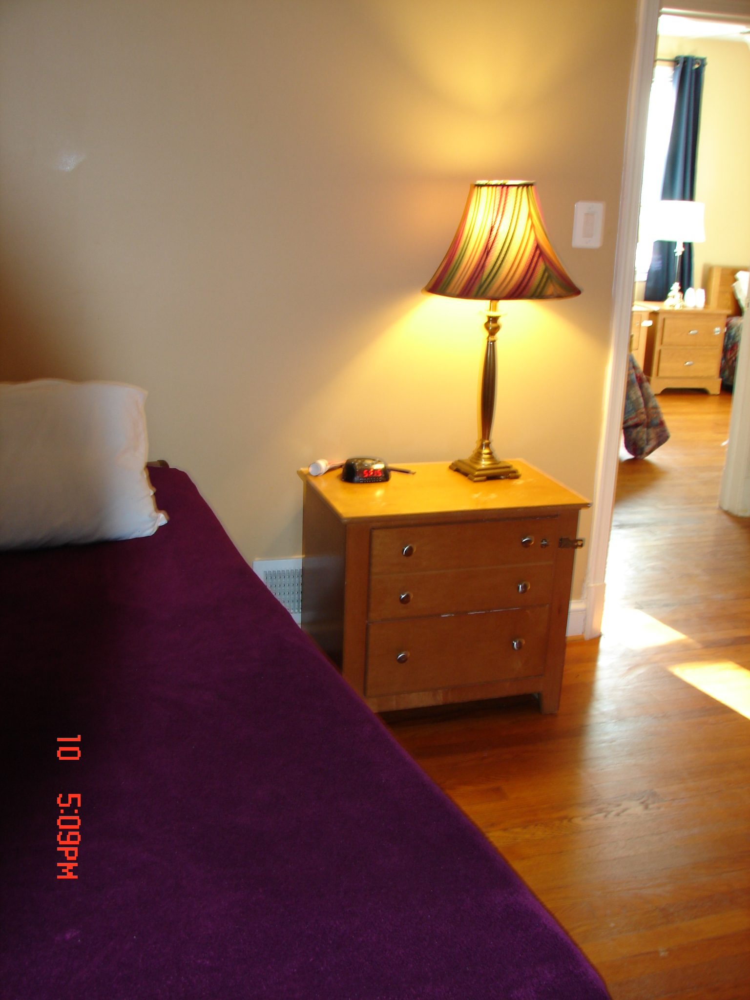 Cozy bedroom with a lamp and dresser.