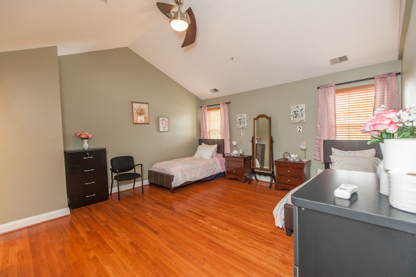Bright private room with wooden floors and a bed