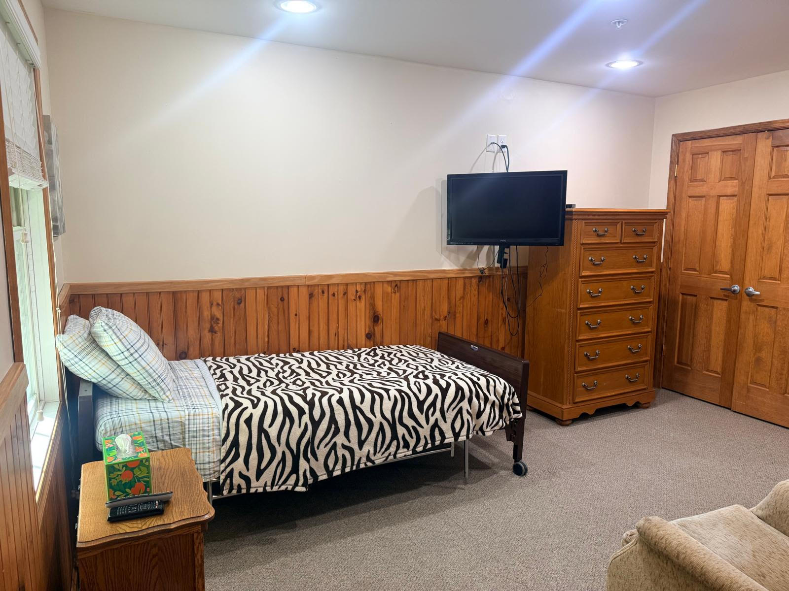 Interior view of a resident room with bed and furniture