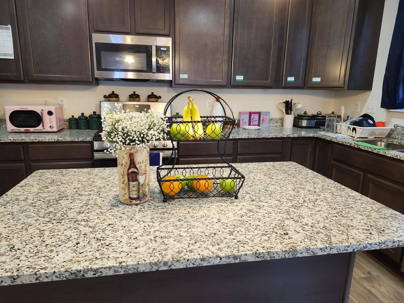 A kitchen countertop with fruits and flowers