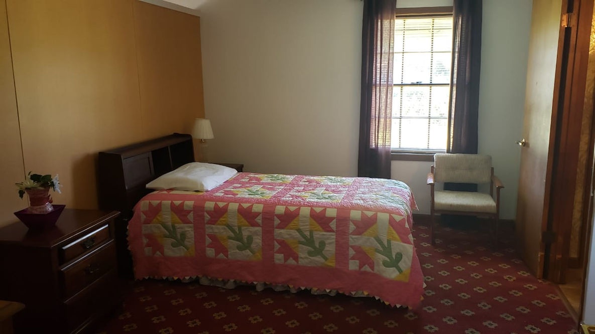 Brightly decorated private resident room with quilt