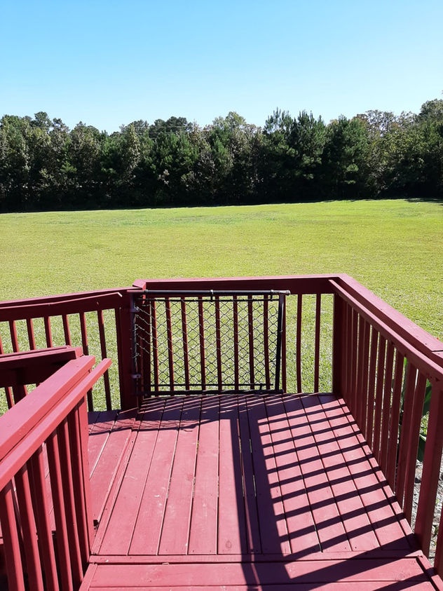 View from a deck overlooking a large green field.